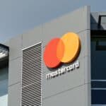Close-up of a modern building facade featuring the red and orange Mastercard logo with partial 'mastercard' text beneath it