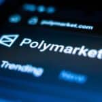 Close-up of a screen showing the Polymarket logo and URL polymarket.com in blue light.