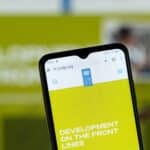 Close-up of a smartphone screen displaying the UNDP website with the UNDP logo on a yellow background.